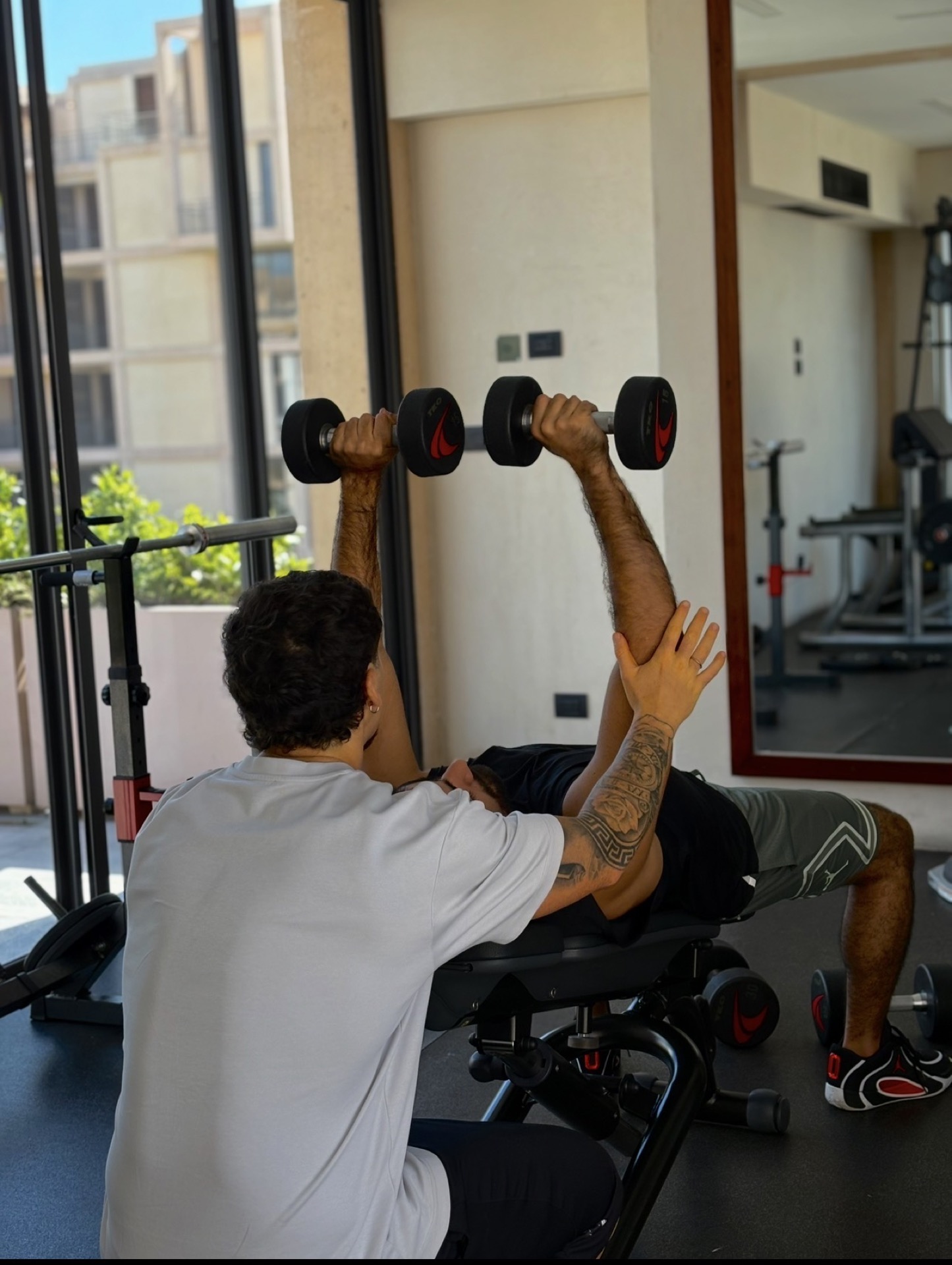 Jeremías Quintana asistiendo a un cliente en el gym — coaching en acción